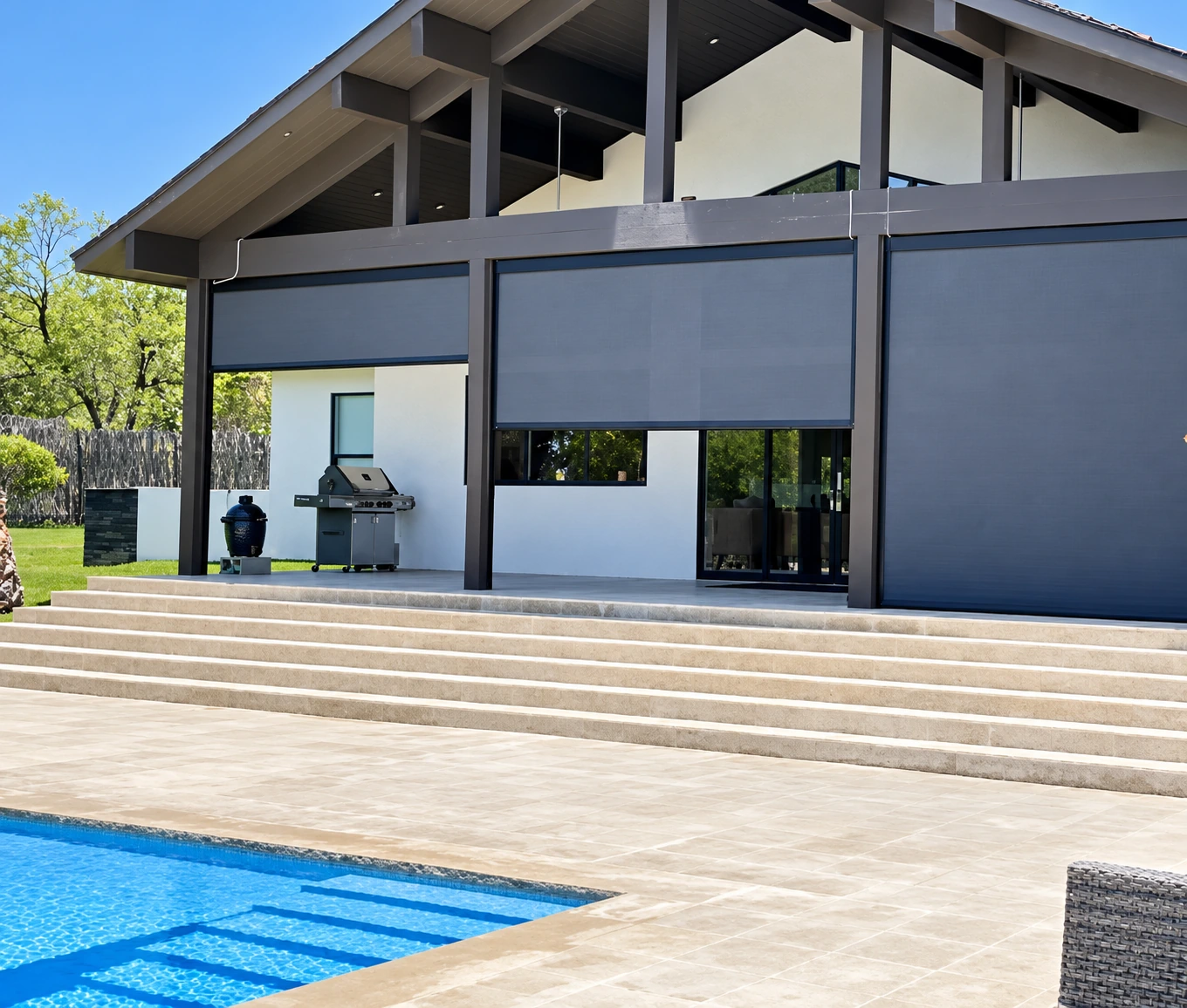 Motorized exterior screens partially lowered across a poolside covered patio.